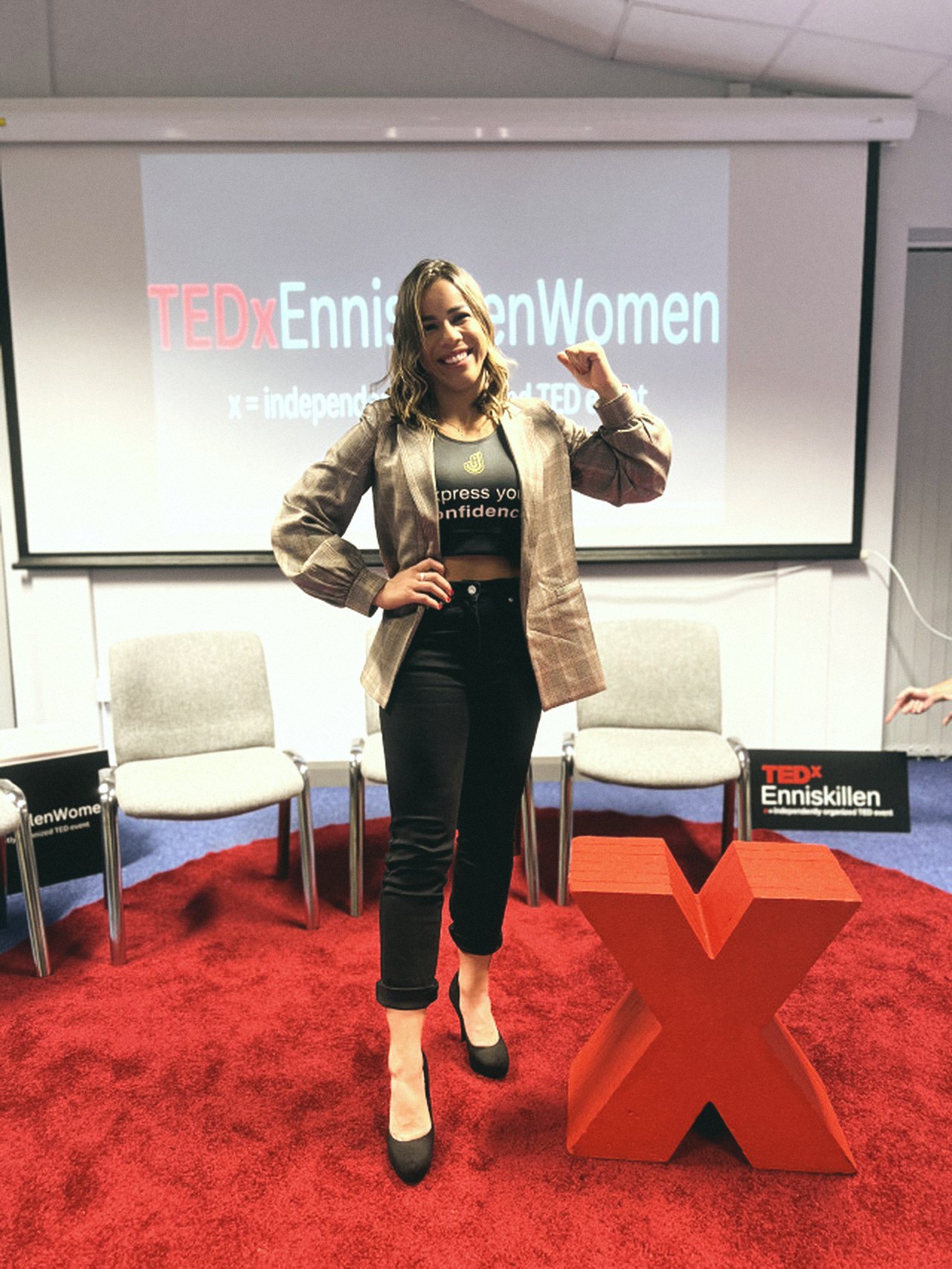 Jaqueline flexing her arm on the TEDx stage