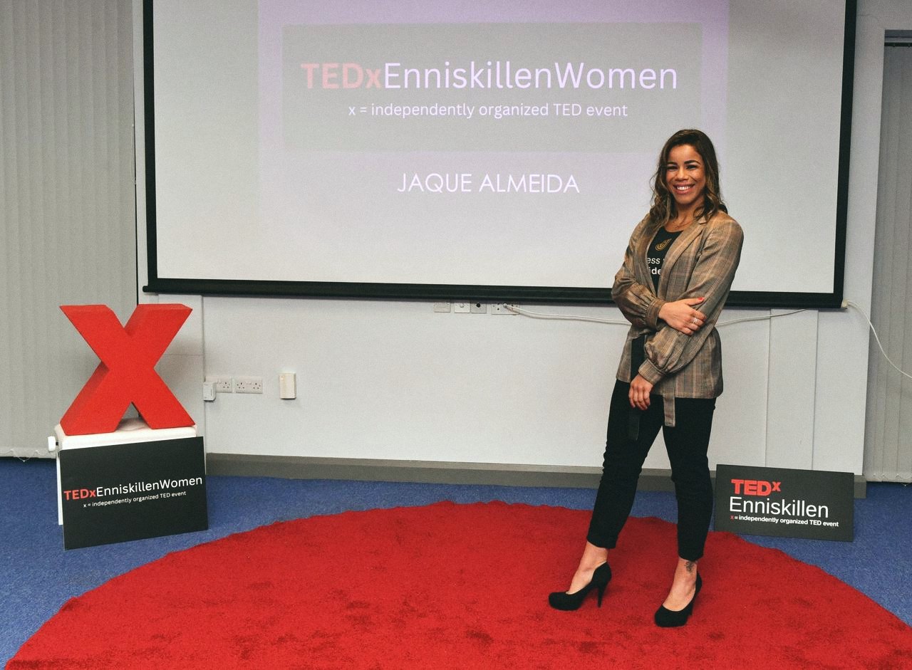 Jaqueline posing beside the TEDx screen
